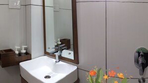 A bathroom with a white sink, a mirror, and a window. There are two soap dispensers on the counter. - Studio Apartment Suite with kitchenette (THIRUVANANTHAPURAM)