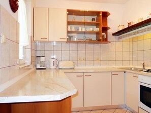 Compact kitchen with central island, oven, and modern sink.