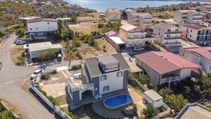 Un barrio residencial con casas modernas, una piscina y vistas al mar.