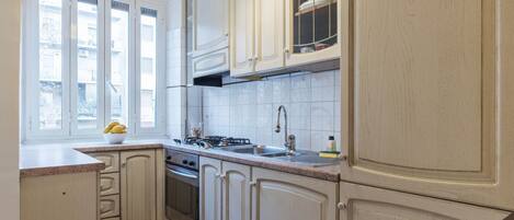 Réfrigérateur, un four, surface de cuisson, vaisselle et ustensiles