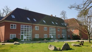 Ein Gebäude aus roten Ziegeln mit großen Fenstern und einem geneigten Dach.