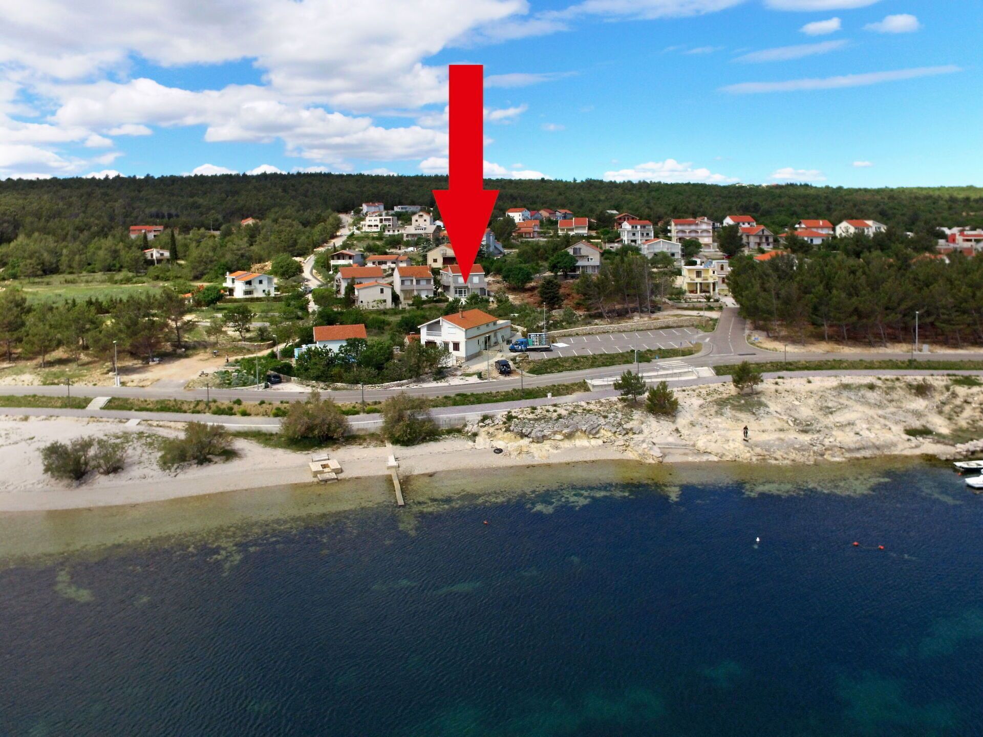 En kystby med huse, vej og strand.