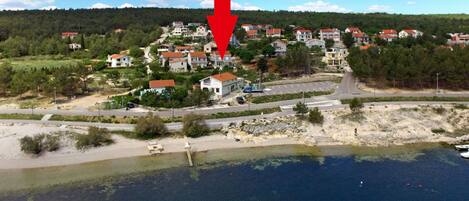 En kystby med huse, vej og strand.