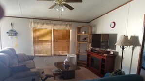 A living room with a sofa, a coffee table, a TV, and a lamp.