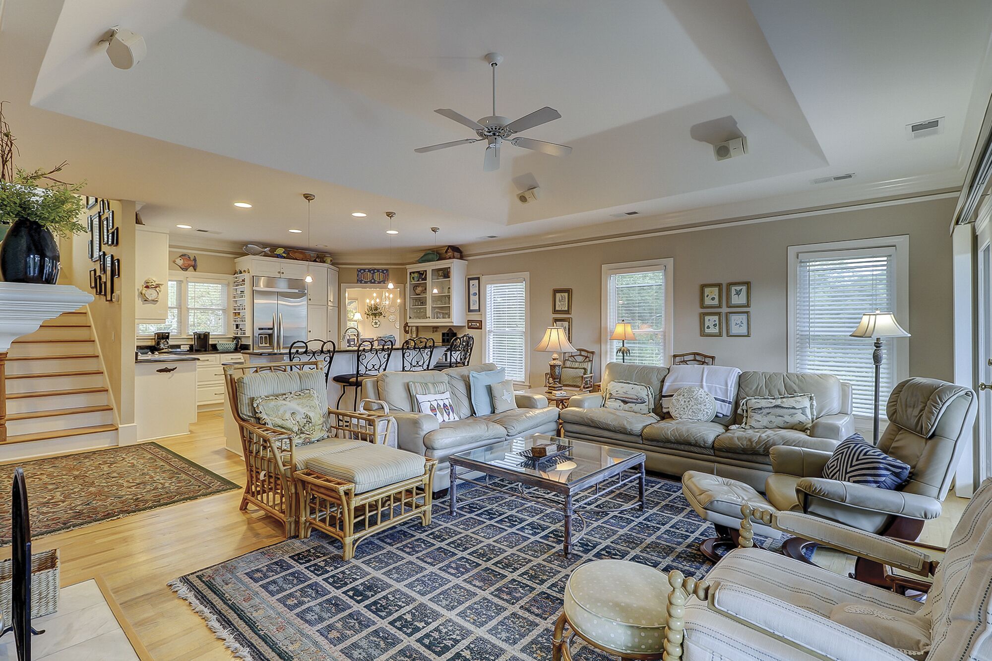 A spacious living room with a large sofa, a coffee table, and a dining area with a kitchen in the background.