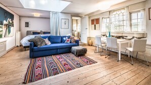 A modern living room with a blue sofa, a colorful rug, and a skylight. - Meeuwen Manor - A treasure near Amsterdam (Edam)