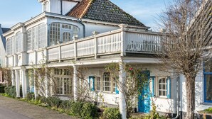 A white building with a tiled roof and blue shutters, featuring large windows and a balcony. - Meeuwen Manor - A treasure near Amsterdam (Edam)
