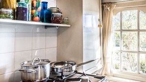 A kitchen with a stove, pots, and a window with curtains. - Meeuwen Manor - A treasure near Amsterdam (Edam)