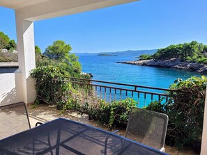 A balcony with a view of the sea, a table, and chairs. - Lovely apartment for 4 guests with WIFI, TV, balcony and pets allowed (Basina)