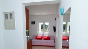 Een kamer met een bed, een tafeltje en een raam met uitzicht op groen.