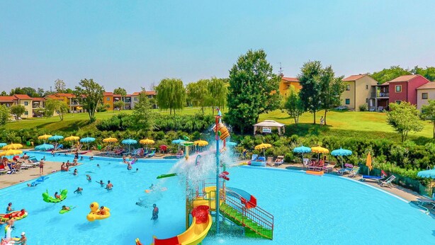 Une grande piscine extérieure dotée de plusieurs toboggans et d’espaces de détente.