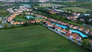 Un quartier résidentiel avec des maisons, une piscine et une vue sur un lac et des montagnes.