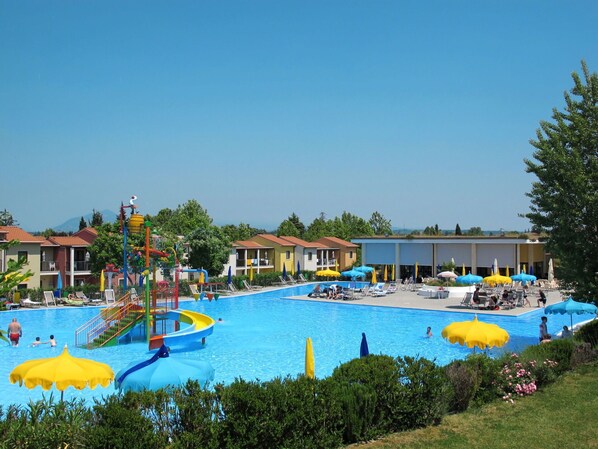 A swimming pool area with multiple water slides and lounge chairs.