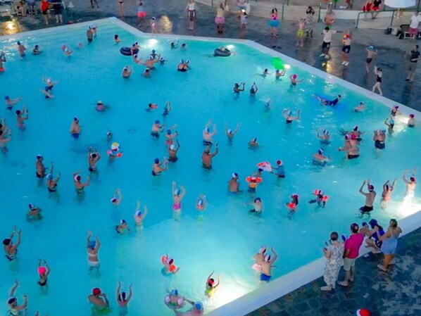 A large indoor swimming pool with multiple lanes and a spectator area.