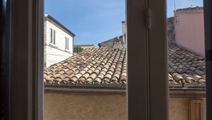 A view through a window of a building with a tiled roof and a visible chimney. - S187 - Sirolo, delightful sky-earth house in the alleys (Sirolo)
