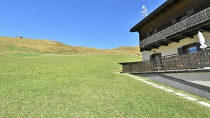 A traditional chalet with a balcony, set against a clear blue sky. - Lovely apartment for 4 guests with WIFI, TV and terrace (Baite)