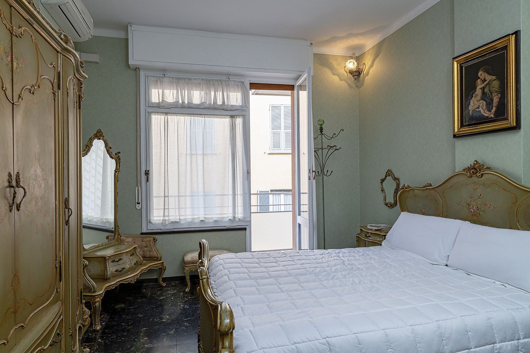 Une chambre à coucher avec un lit, une commode, un miroir et une fenêtre.