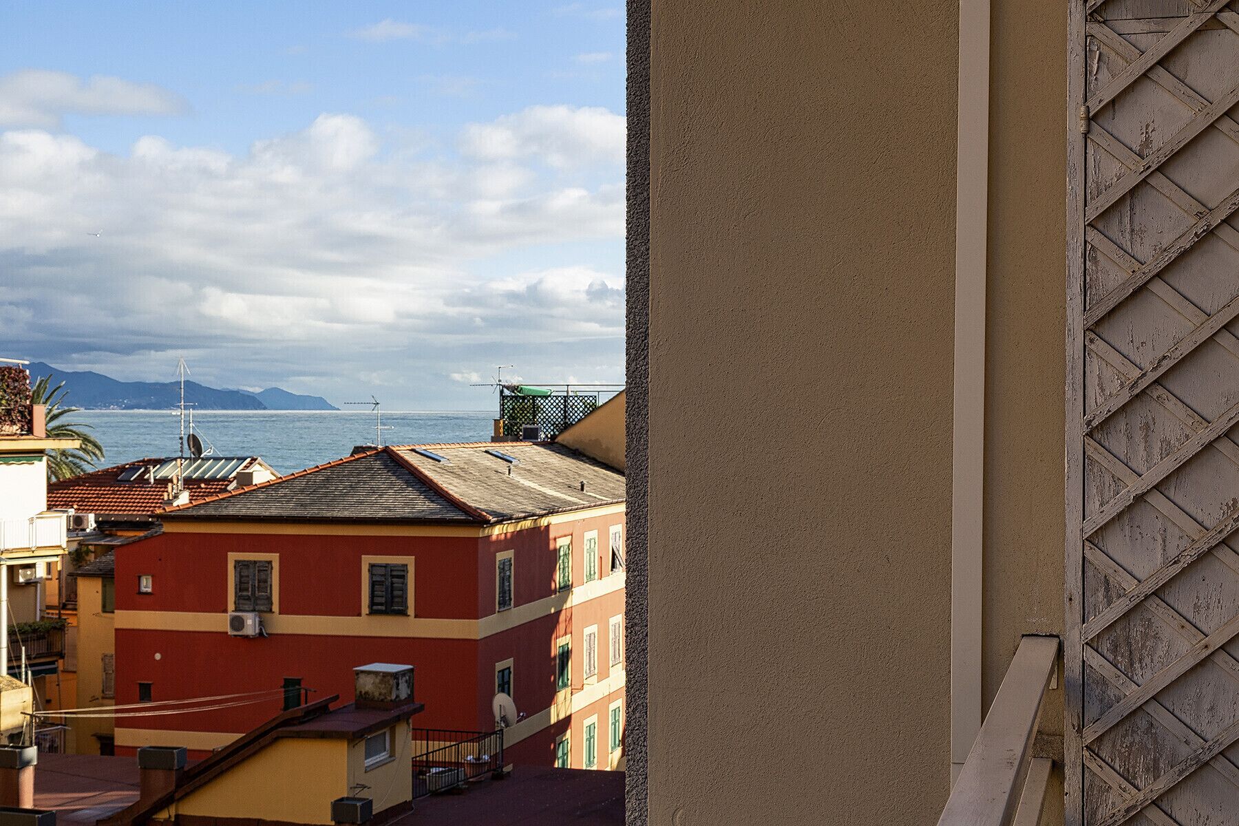 A coastal cityscape with buildings and a view of the sea.