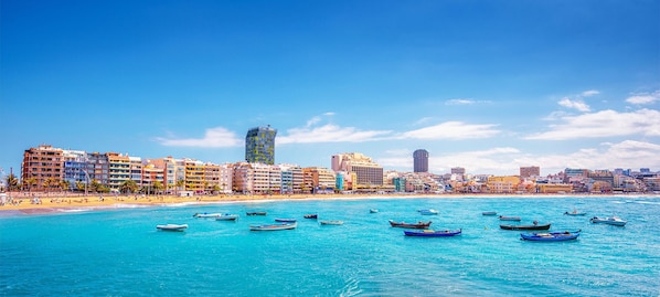 Una playa cerca, sillas reclinables de playa, toallas de playa
