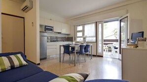 Un espacio habitable compacto con kitchenette, comedor y dormitorio con sofá.