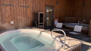 Ett bubbelbad med en träplattform, en dörr med ett glasparti och en skylt som varnar för varmt vatten.