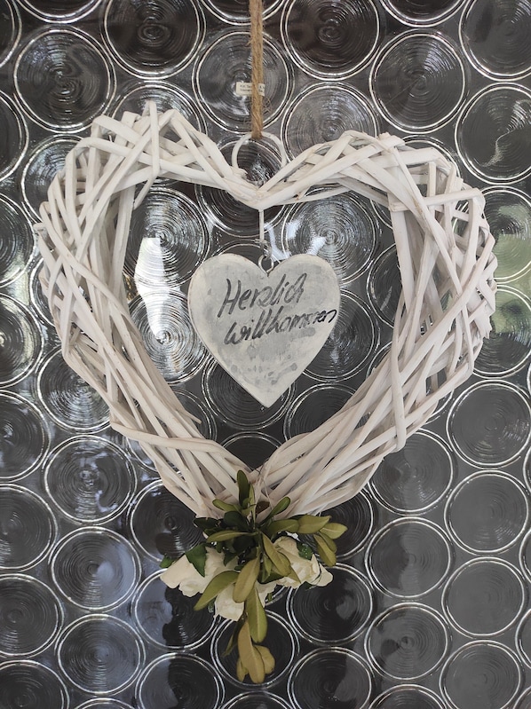 A heart-shaped decoration with a message, surrounded by a circular pattern. - Large ground floor apartment with winter garden (Marktoberdorf)