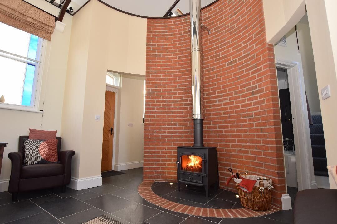 A living room with a brick fireplace, a sofa, and a chair.