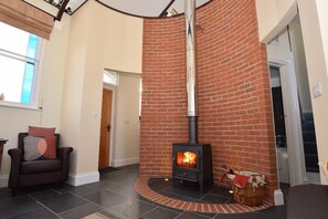 A living room with a brick fireplace, a sofa, and a chair. - Retreat to a Former Chapel, Peaceful location, ideal for privacy and relaxation. (Toynton All Saints)