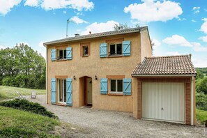 A two-story house with a garage, a covered porch, and a gravel driveway. - CONFORTABLE HOUSE - NATURE - QUIET (LE VERDIER)