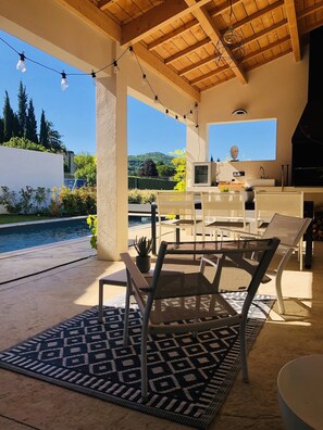 An outdoor patio with a pool, chairs, and a kitchen area. - Deluxe villa with private pool and beautiful mountain view  (Malaucène)