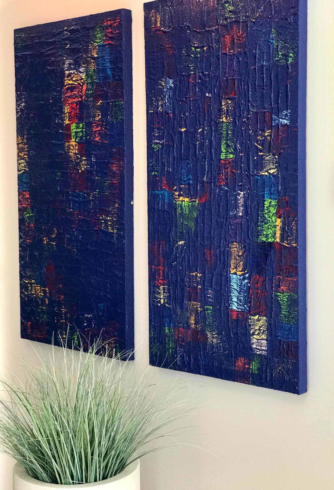 Deux tableaux abstraits accrochés à un mur.