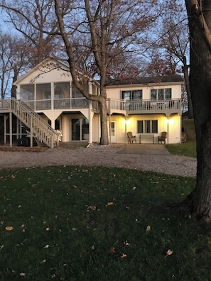 A two-story house with a balcony, a staircase, and a lawn. - Tippy Cottage on the Lake (Leesburg)