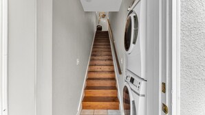 Un escalier étroit avec des marches en bois menant à une buanderie.