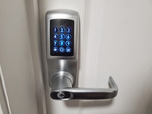 A modern digital door lock with a keypad and a lever handle. - Sleeplicity London Heathrow (Feltham)