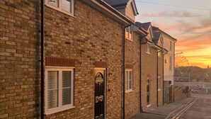 A row of brick houses with uniform architecture, a clear sky, and a sunset. - Little Eaton - Hidden Gem - Location by the sea with FREE parking  (Margate)