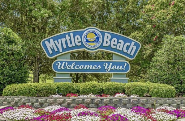 A sign for Myrtle Beach with the text 'Myrtle Beach' and 'Welcome You!'