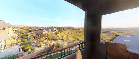 A balcony with a view of a residential area and a golf course.