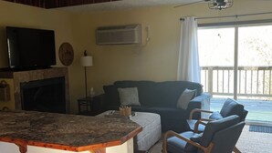 A living room with a TV, fireplace, and a sign that reads "Welcome to the Lake House." - Fishermen and Family’s Lakeside Nature Retreat  (Cape Fair)