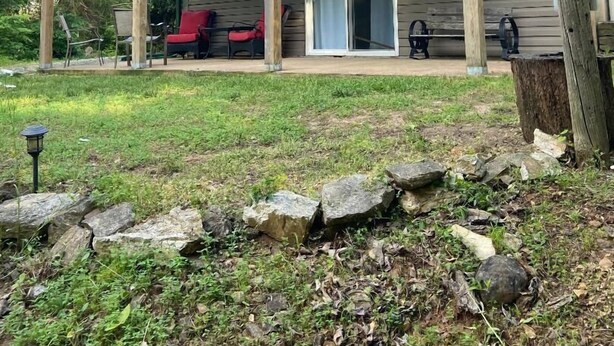 A wooden building with a covered porch and a sign reading "Fishhole". - Fishermen and Family’s Lakeside Nature Retreat  (Cape Fair)