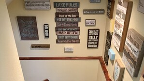 A staircase with wooden steps and a handrail, surrounded by motivational signs on the walls. - Fishermen and Family’s Lakeside Nature Retreat  (Cape Fair)