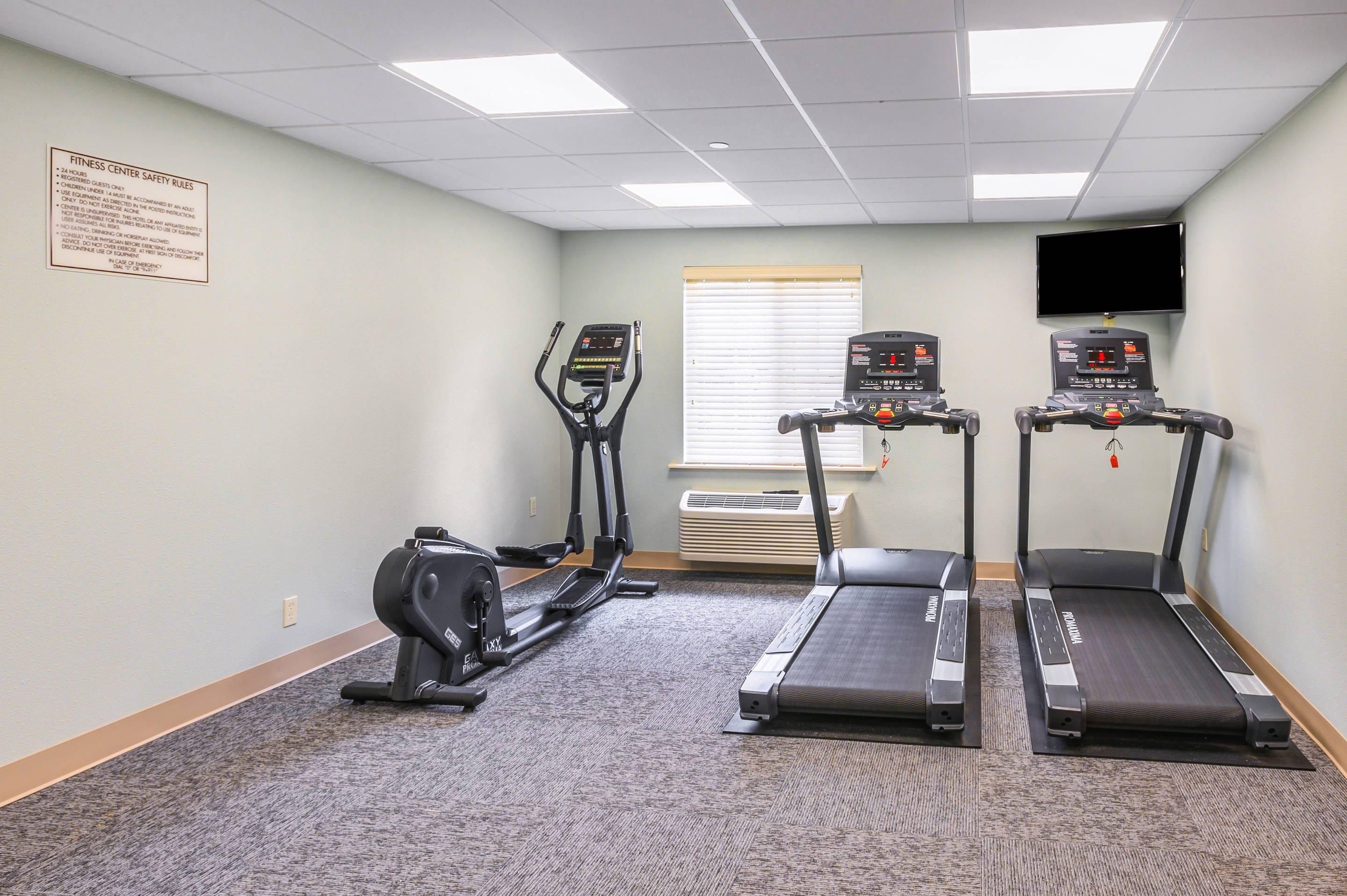 Un centre de remise en forme équipé de tapis de course, d’un vélo elliptique et d’un vélo d’appartement.