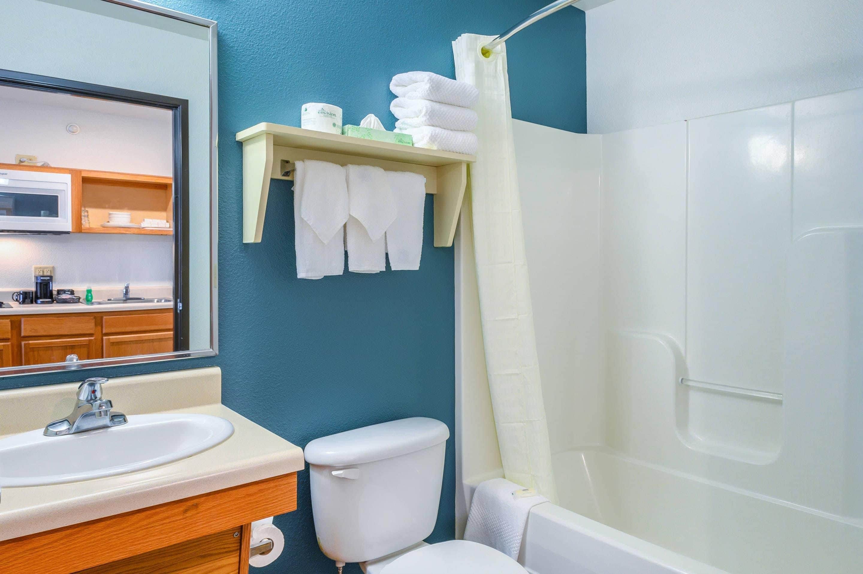A bathroom with a sink, toilet, and shower.