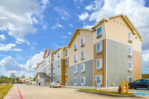 En flervåningsbyggnad med bostäder, ett platt tak, flera fönster och en parkeringsplats med en brandpost.
