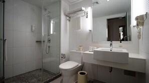 A modern bathroom with a glass-enclosed shower, a white sink, and a mirror above the sink. - JI Hotel (Shanghai)