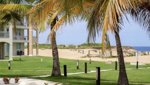 Ein Resort mit Palmen, einem Strand und einem Gebäude mit Balkonen.
