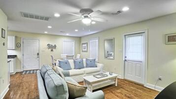 A living room with a sectional sofa, a coffee table, and a ceiling fan.