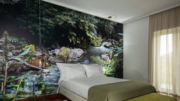 A bedroom with a large mural of a forest scene, a bed with white linens, and a bench.