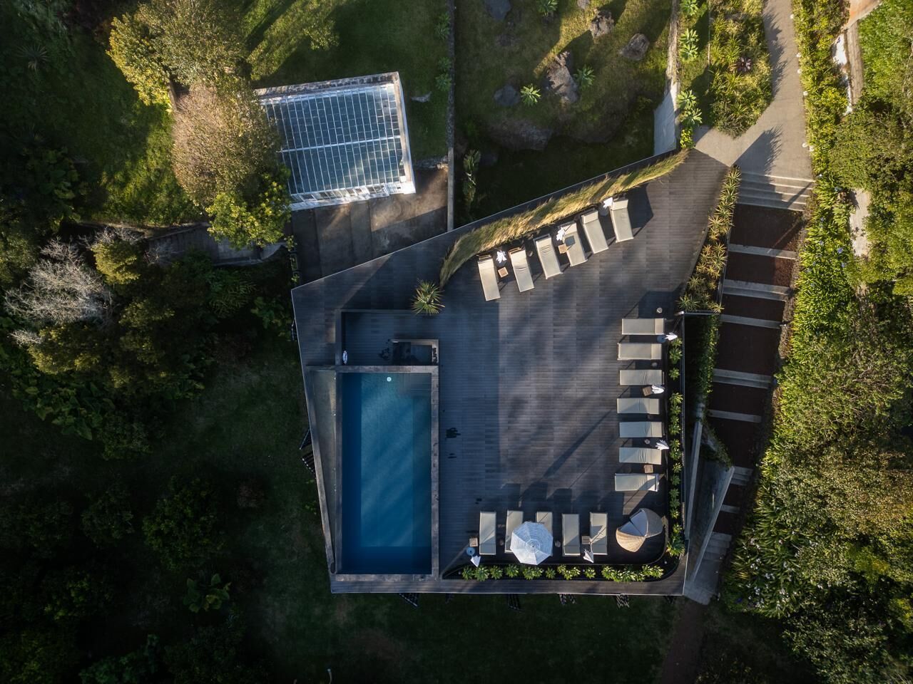 Vista aérea de una azotea con piscina, tumbonas y un panel solar.