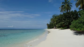 On the beach, white sand, beach towels, beach volleyball