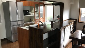 A modern kitchen with stainless steel appliances, wooden cabinets, and a central island with a sink.